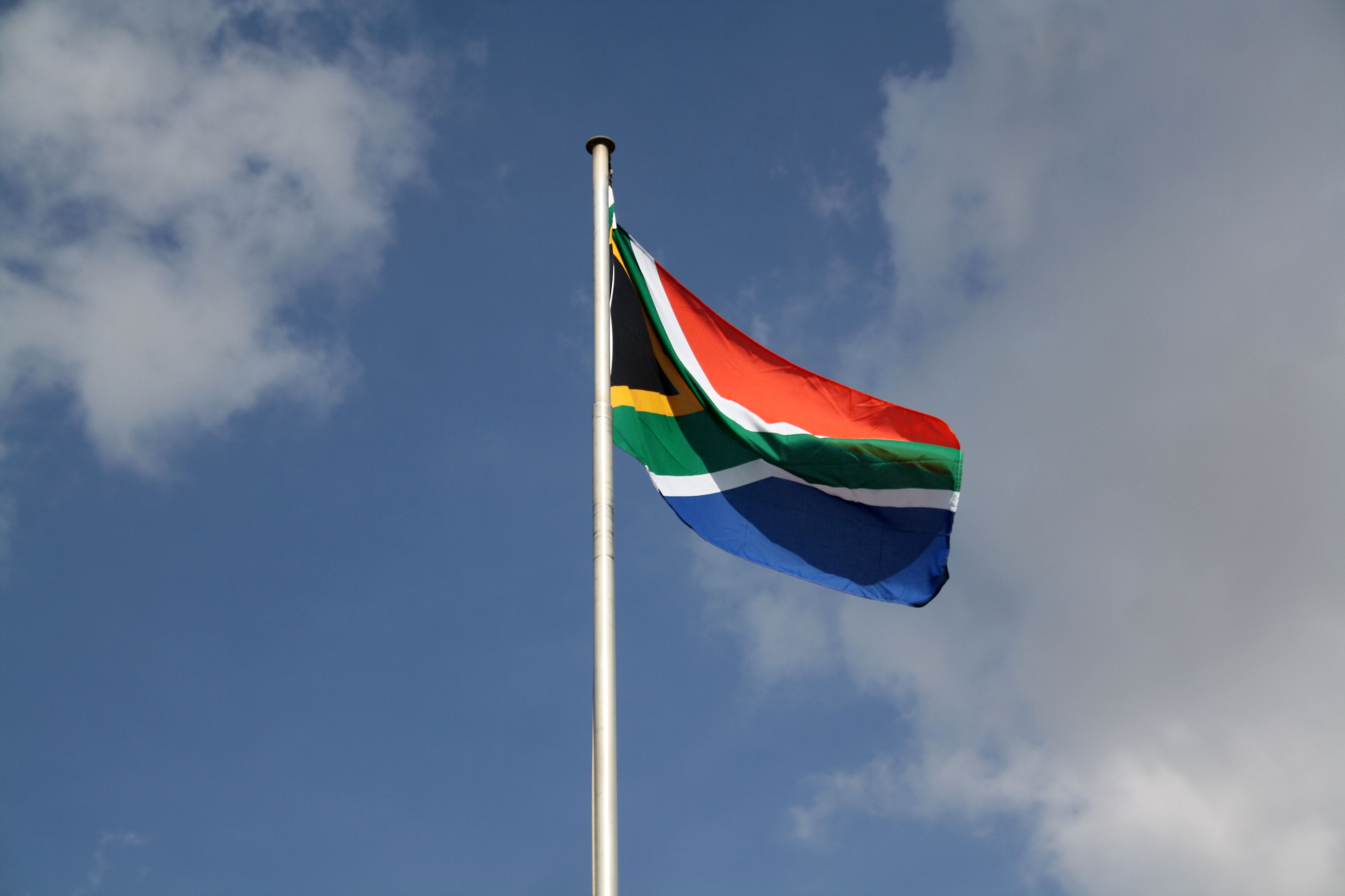 The South African flag flying against a blue sky